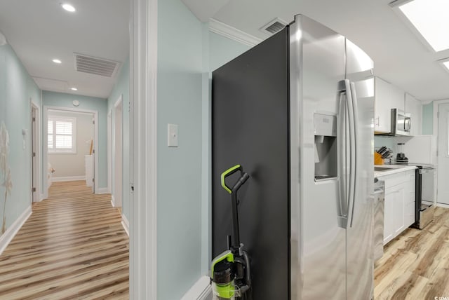 hallway with light hardwood / wood-style floors