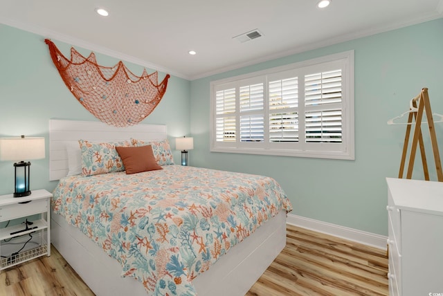 bedroom with light hardwood / wood-style flooring and crown molding