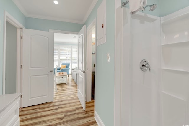 hallway featuring crown molding and light hardwood / wood-style floors