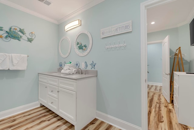 bathroom with vanity, hardwood / wood-style floors, and crown molding