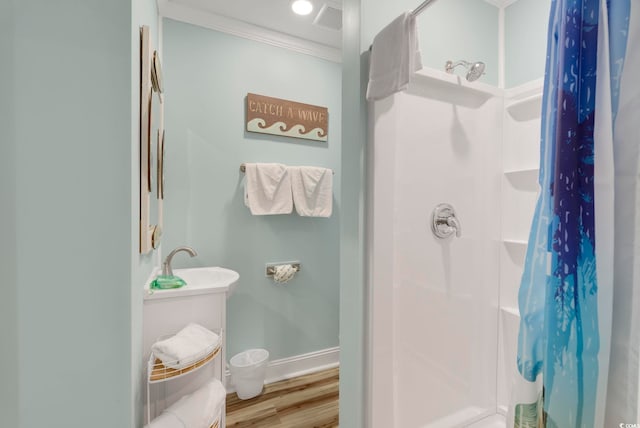 bathroom with hardwood / wood-style floors, crown molding, and a shower with shower curtain