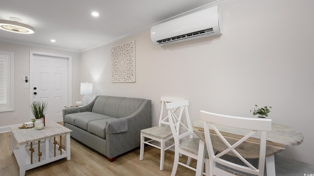 living room featuring ornamental molding, light hardwood / wood-style floors, and a wall unit AC