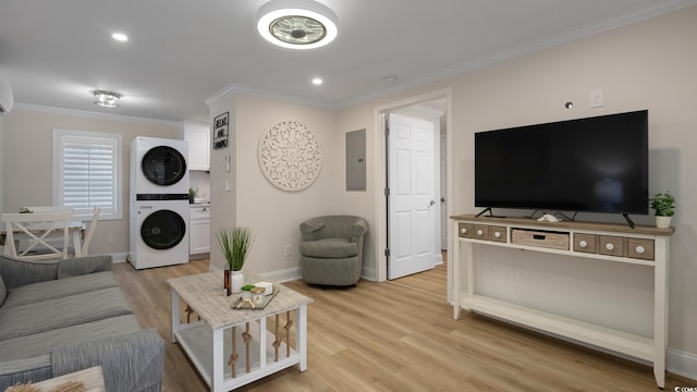 living room featuring electric panel, light hardwood / wood-style flooring, stacked washer / dryer, and crown molding