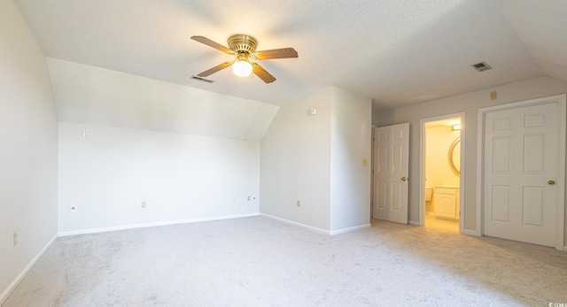 additional living space with a textured ceiling, ceiling fan, lofted ceiling, and light carpet