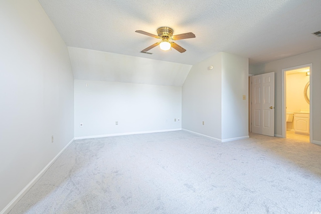 bonus room featuring a textured ceiling, ceiling fan, light carpet, and vaulted ceiling