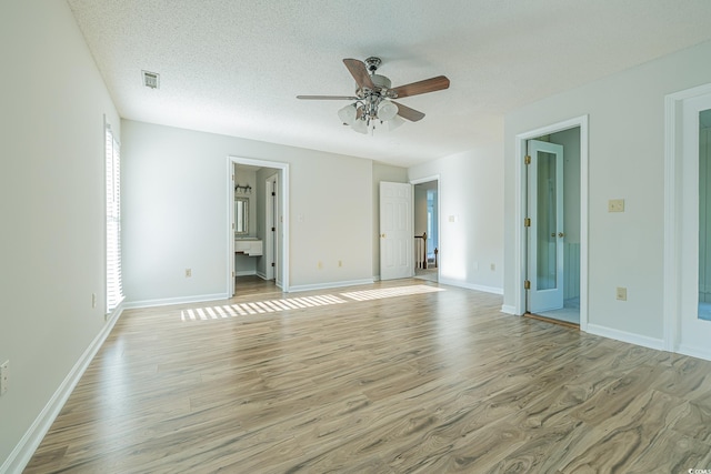 empty room with a textured ceiling, light hardwood / wood-style flooring, and ceiling fan