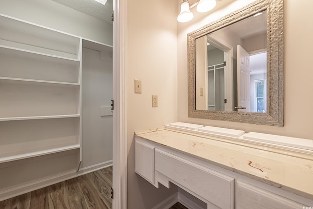 bathroom with vanity, hardwood / wood-style floors, and a textured ceiling