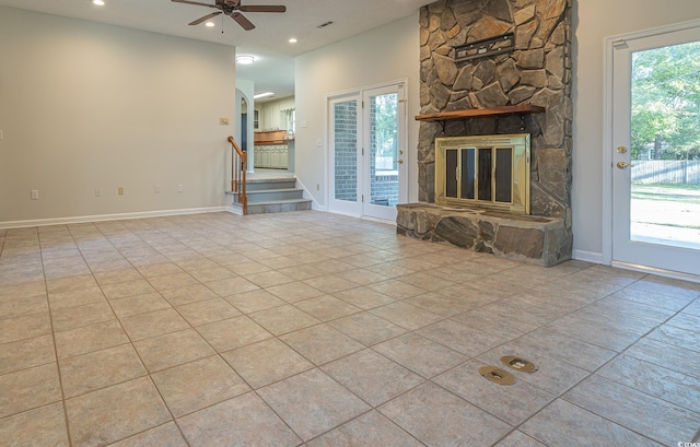 unfurnished living room with plenty of natural light, ceiling fan, light tile patterned flooring, and a fireplace