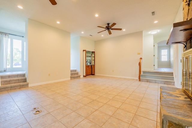 tiled spare room featuring ceiling fan