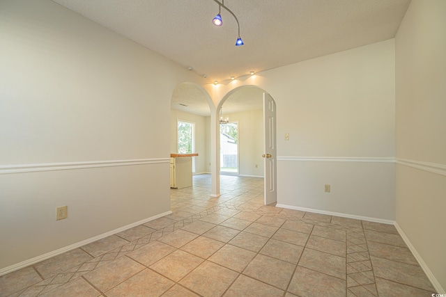 unfurnished room featuring light tile patterned floors and a textured ceiling