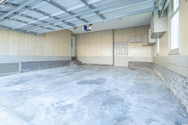 garage with wood walls and a garage door opener