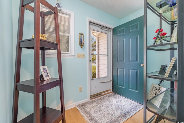 entryway with wood-type flooring and a textured ceiling