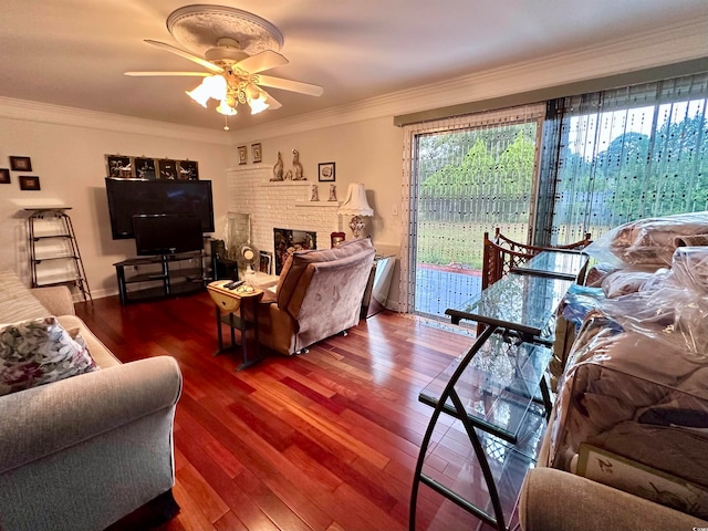 living room with ceiling fan, wood-type flooring, ornamental molding, and a fireplace