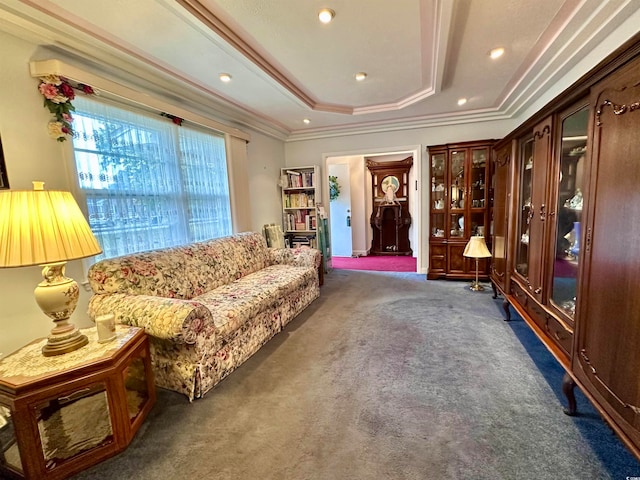 living area featuring a tray ceiling, dark carpet, and crown molding