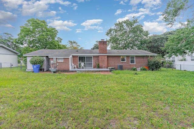 back of house with central AC and a lawn