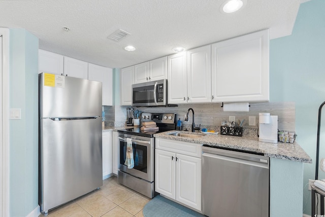 kitchen featuring tasteful backsplash, white cabinetry, sink, and stainless steel appliances