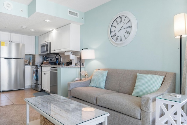 living room featuring sink and light tile patterned flooring