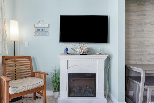 sitting room with carpet floors and wooden walls