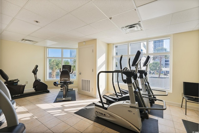 exercise area featuring light tile patterned floors and a drop ceiling