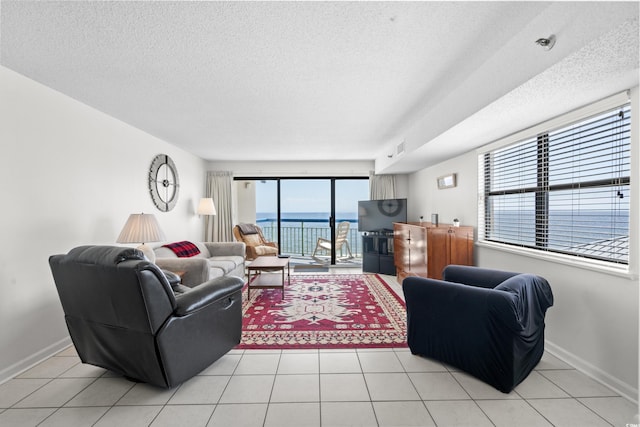 living room featuring a textured ceiling, light tile patterned flooring, and baseboards