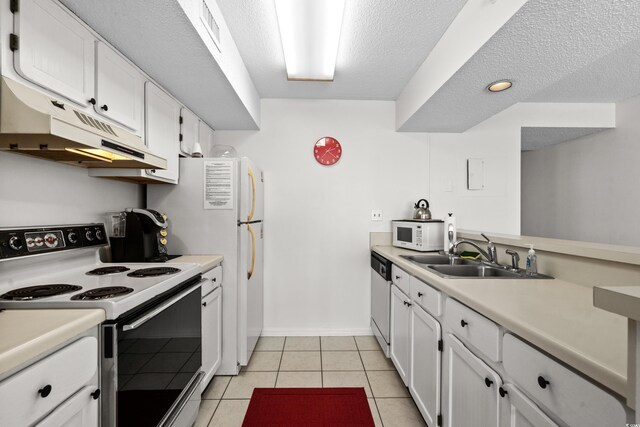 kitchen with sink, light tile patterned floors, white appliances, and white cabinets