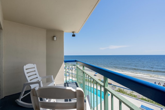 balcony featuring a water view and a beach view