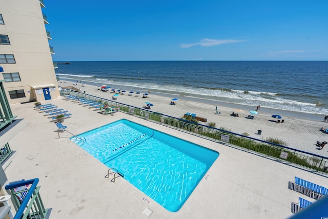 view of pool with a water view and a beach view