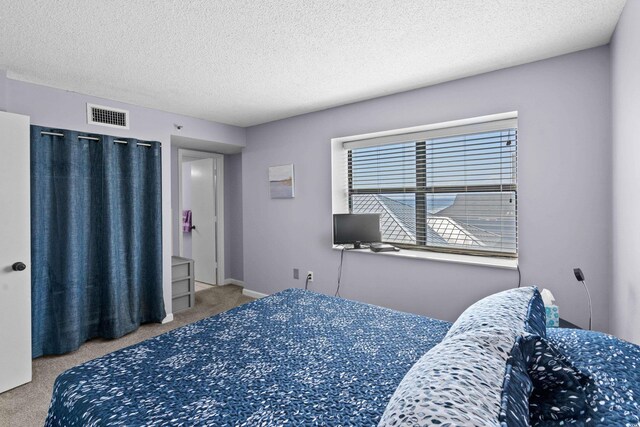 bedroom featuring light carpet and a textured ceiling