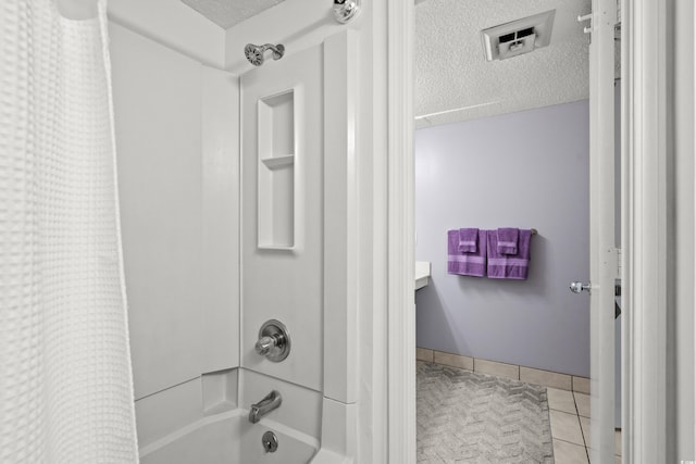 bathroom featuring a textured ceiling, tile patterned flooring, and shower / bath combo