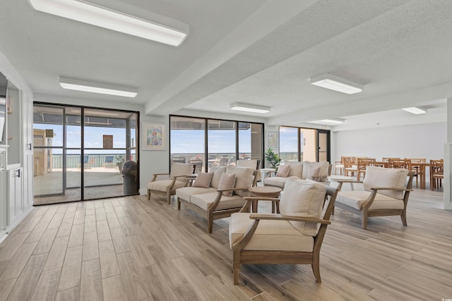 living room featuring a textured ceiling, plenty of natural light, and light wood-type flooring