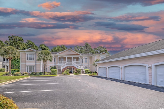 property at dusk with a garage and stairway