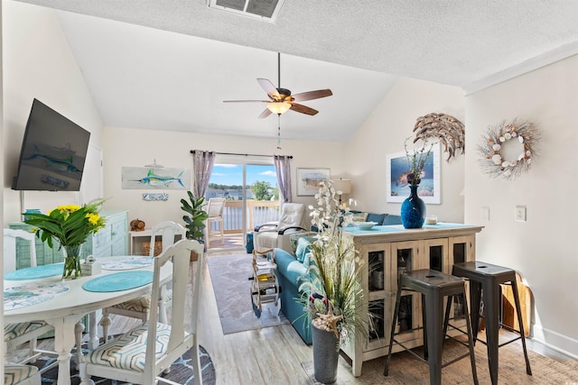 interior space with light hardwood / wood-style flooring, ceiling fan, a textured ceiling, and vaulted ceiling