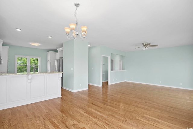 interior space featuring ceiling fan with notable chandelier and light hardwood / wood-style floors