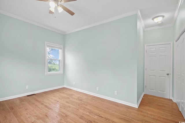 spare room with a textured ceiling, ornamental molding, ceiling fan, and light hardwood / wood-style flooring