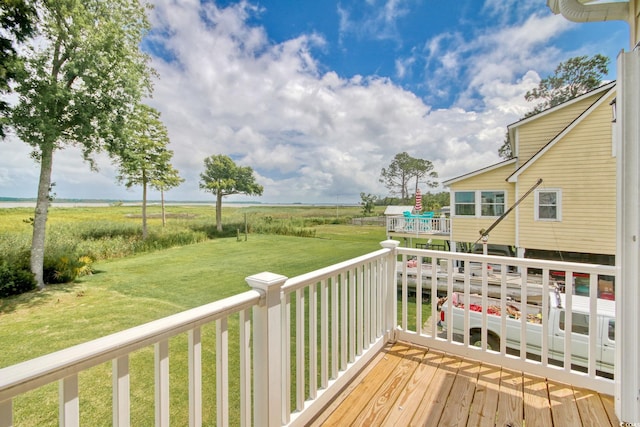 wooden deck with a rural view and a yard