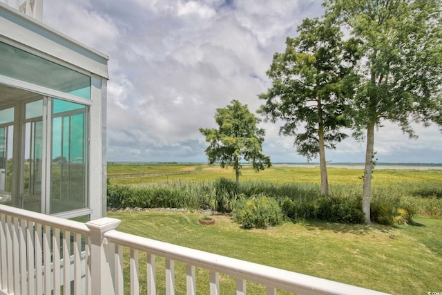 view of yard with a balcony and a rural view