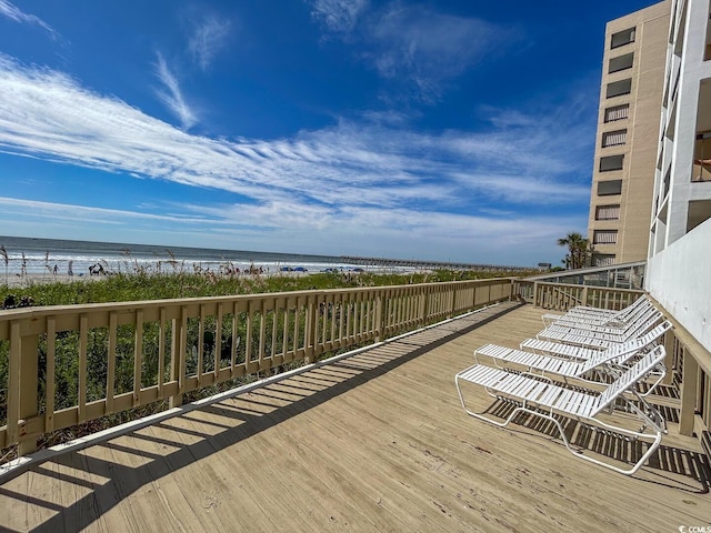 wooden terrace with a view of the beach and a water view