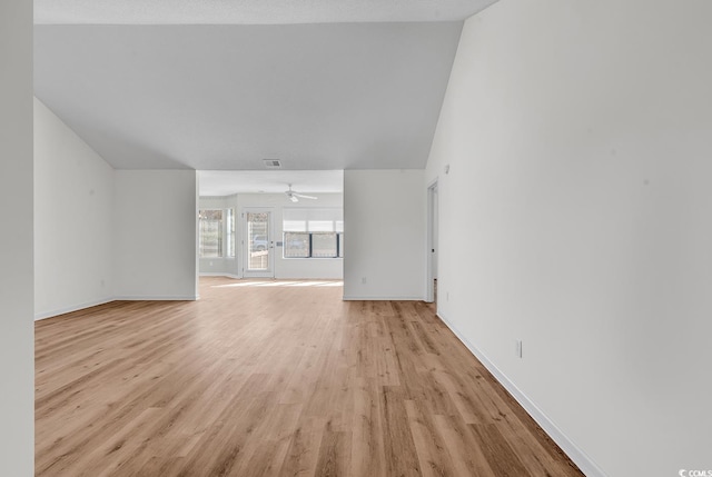 unfurnished living room featuring ceiling fan, vaulted ceiling, a textured ceiling, and light hardwood / wood-style flooring