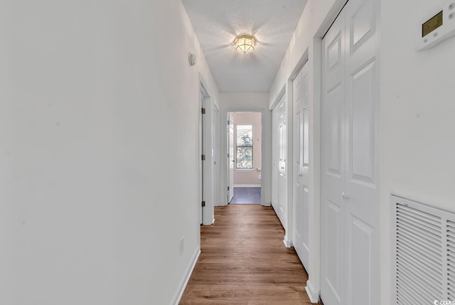 hallway featuring a textured ceiling and light wood-type flooring