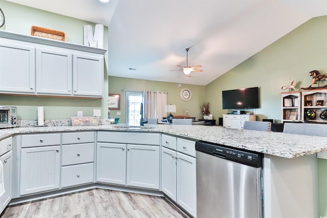 kitchen with light hardwood / wood-style floors, vaulted ceiling, light stone counters, ceiling fan, and stainless steel dishwasher