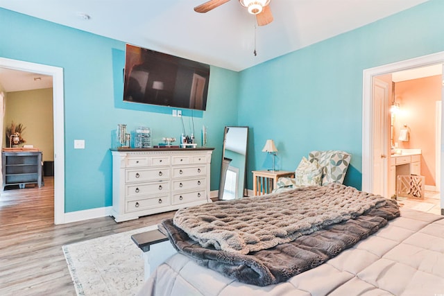 bedroom featuring ceiling fan, light wood-type flooring, and ensuite bath