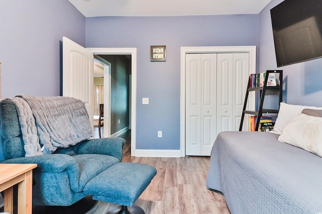 bedroom with light hardwood / wood-style floors and a closet