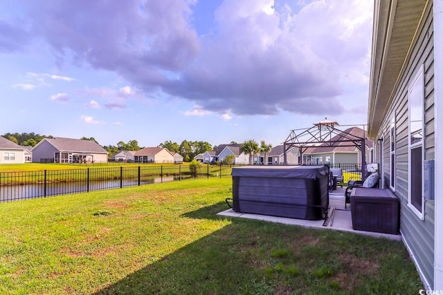 view of yard featuring a gazebo, a water view, and a hot tub