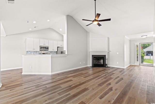 unfurnished living room featuring high vaulted ceiling, ceiling fan, and hardwood / wood-style flooring