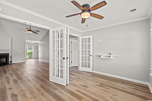 interior space with ceiling fan, light hardwood / wood-style floors, crown molding, and french doors