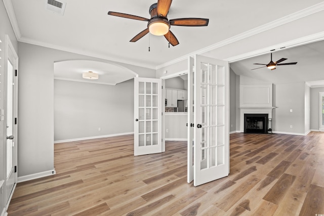 unfurnished living room with french doors, vaulted ceiling, ceiling fan, and light hardwood / wood-style floors