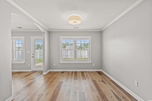 empty room with ornamental molding and light wood-type flooring