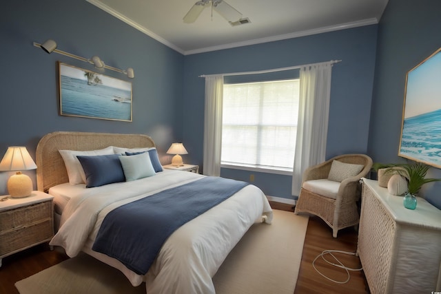 bedroom featuring visible vents, baseboards, a ceiling fan, wood finished floors, and crown molding