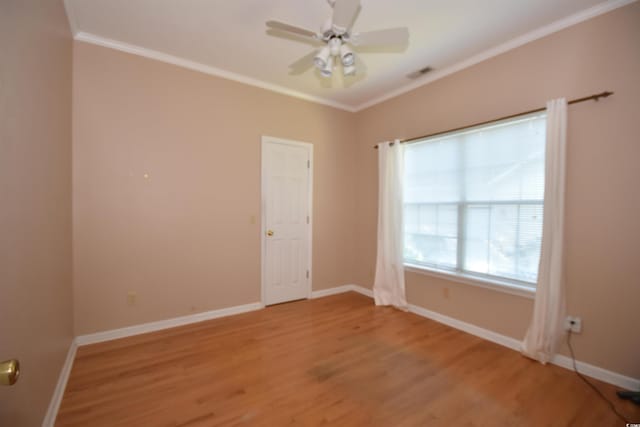 unfurnished room with light wood-style floors, baseboards, ornamental molding, and a ceiling fan