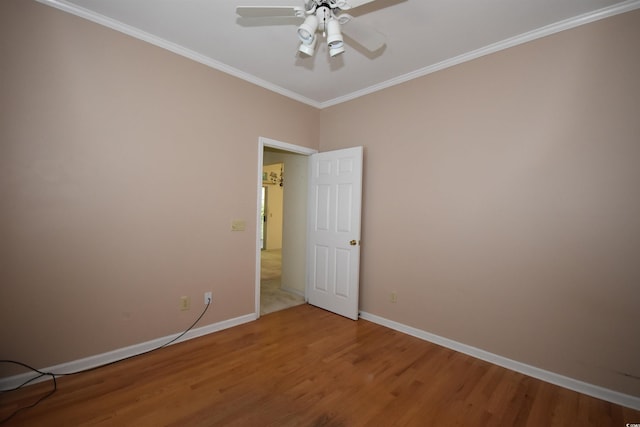 unfurnished room featuring crown molding, baseboards, and wood finished floors